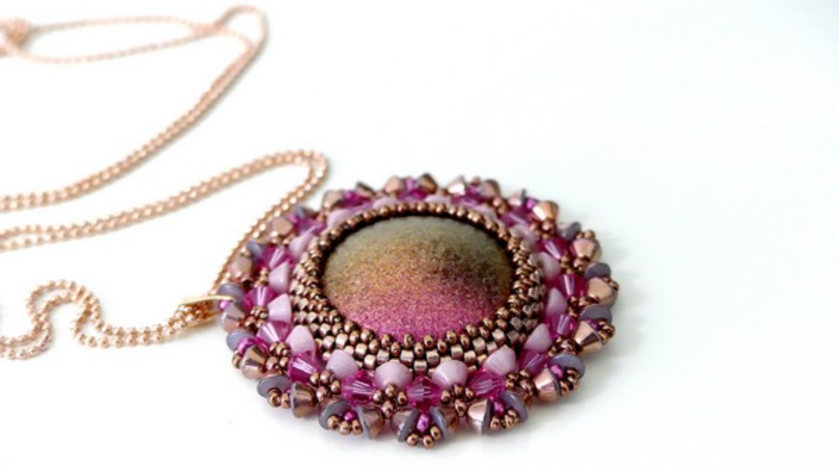 K'amille pendant with cabochon, Konos glass beads by Puca, and Pure Crystal bicones K'amille pendant with cabochon, Konos glass beads by Puca, and Pure Crystal bicones