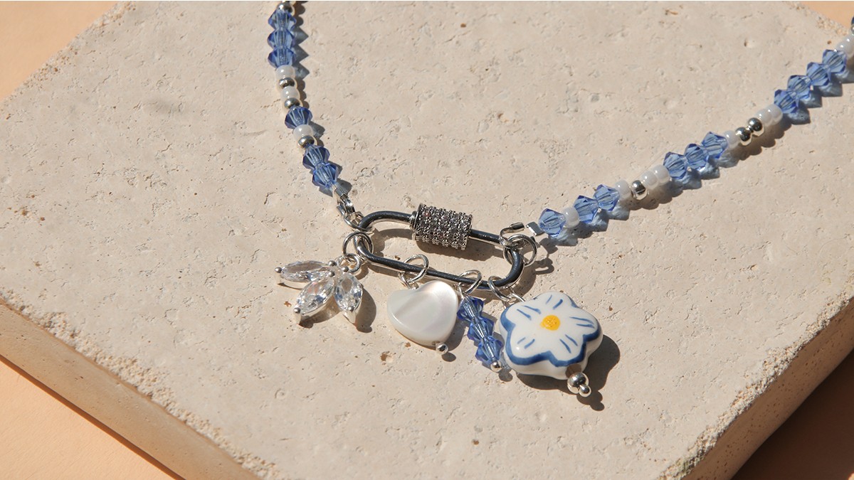 Necklace with lobster clasp, blue spinning tops and accumulation of charms Necklace with lobster clasp, blue spinning tops and accumulation of charms