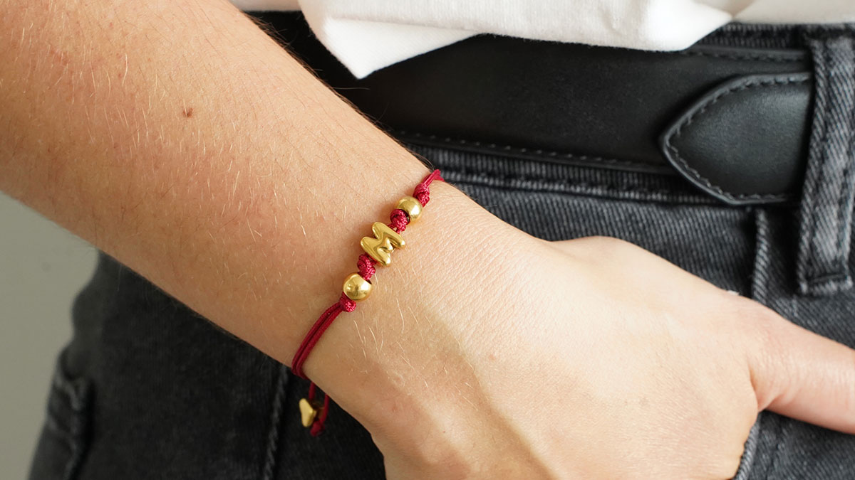 Cord bracelet with an earring back charm Cord bracelet with an earring back charm